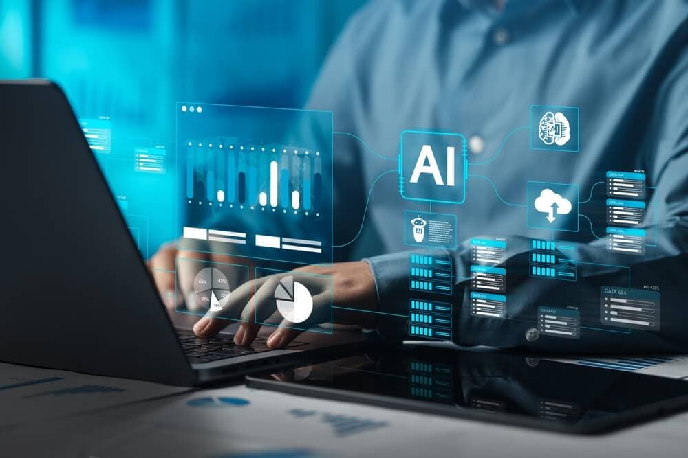 Person typing on a laptop with holographic AI and data analytics graphics overlaid, including charts, cloud icons, and an 'AI' symbol